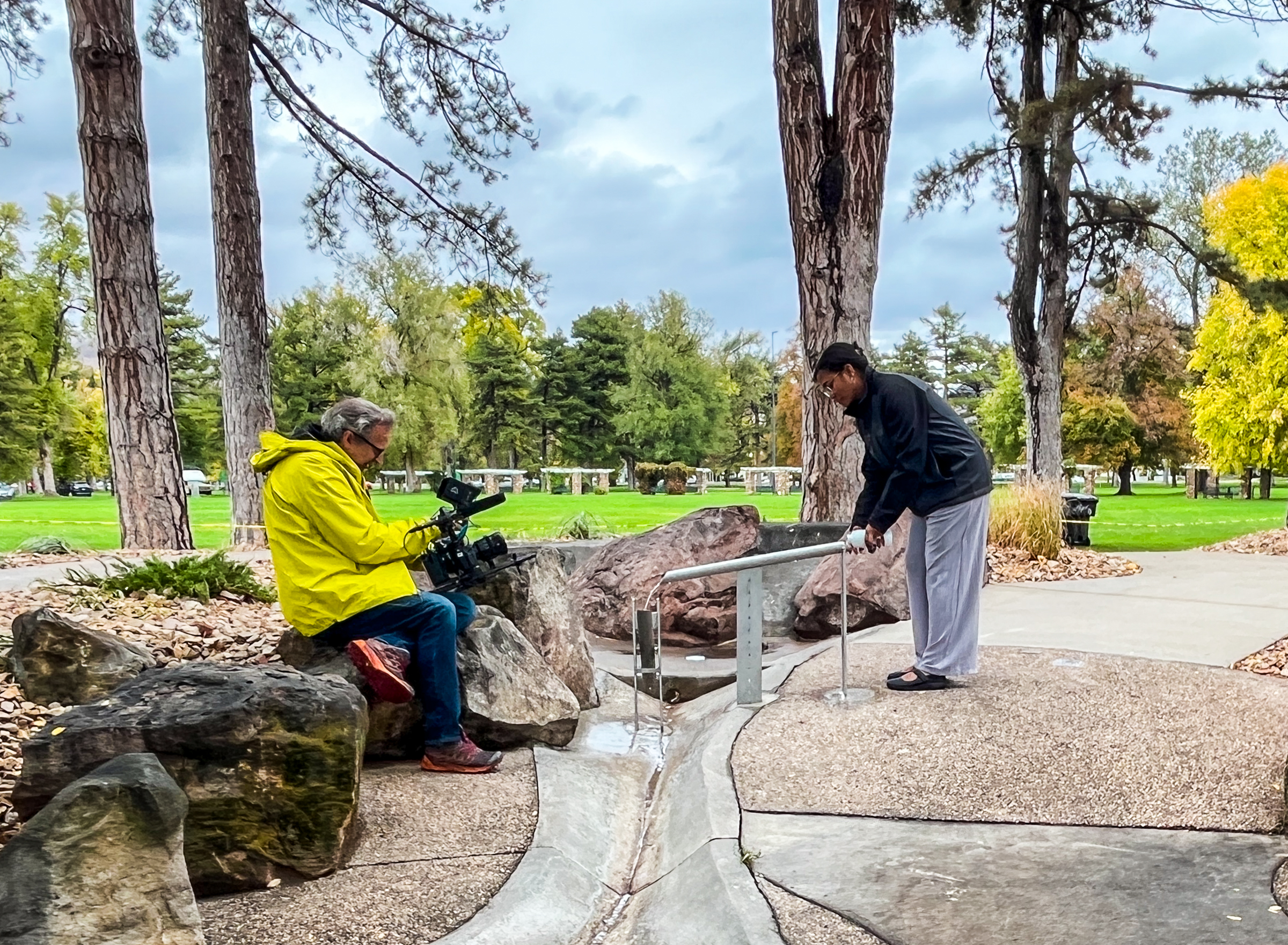 A person pours water into a shishi-odoshi Japanese rock water fountain feature included in Liberty Park's Seven Canyon Refuge on Thursday.
