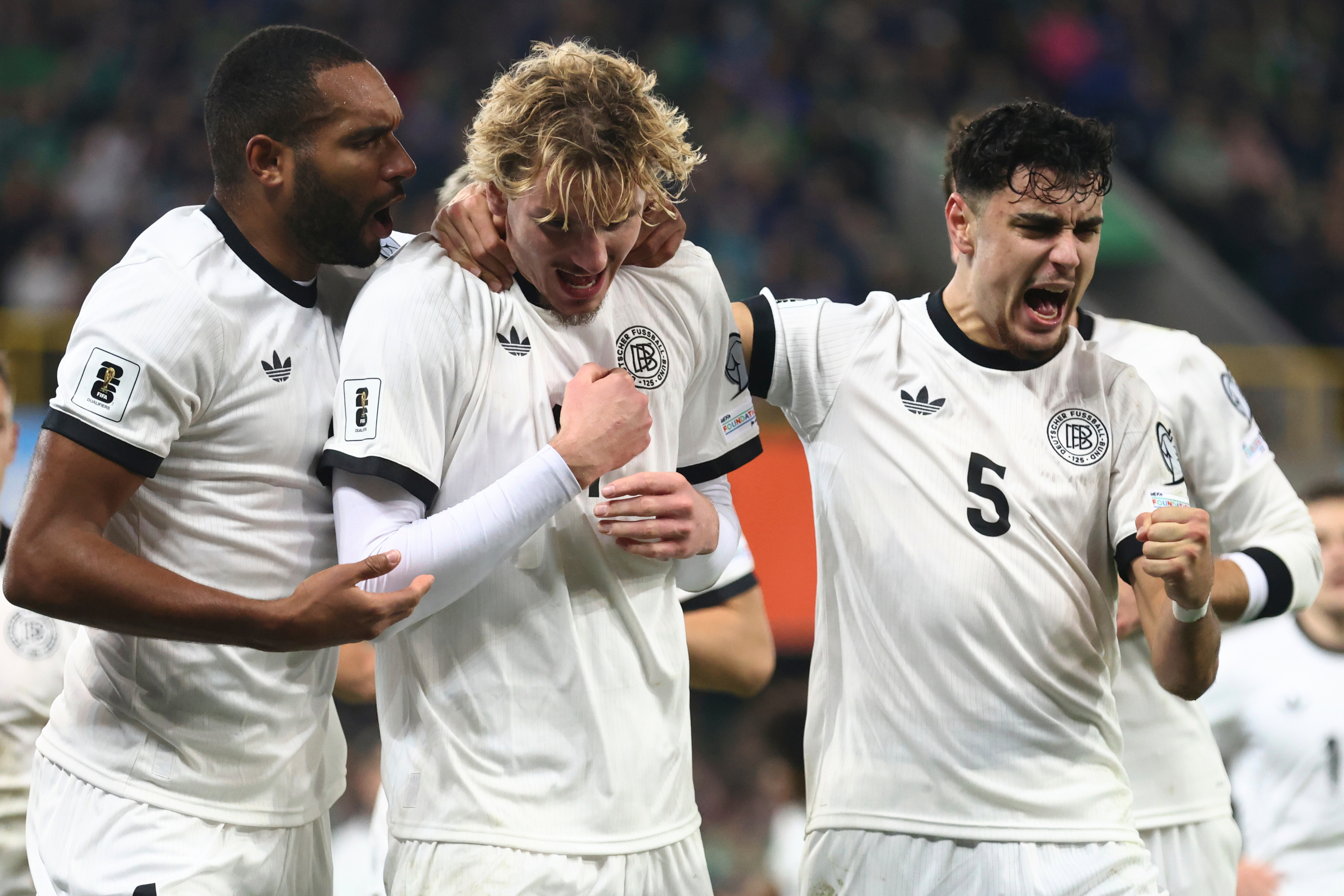 Germany's Nick Woltemade, center, celebrates with teammates Aleksandar Pavlovic, right, and Jonathan Tah, after scoring the opening goal of his team during the World Cup 2026 group A qualifying soccer match between Northern Ireland and Germany at Windsor Park stadium, in Belfast, Northern Ireland, Monday, Oct. 13, 2025. 