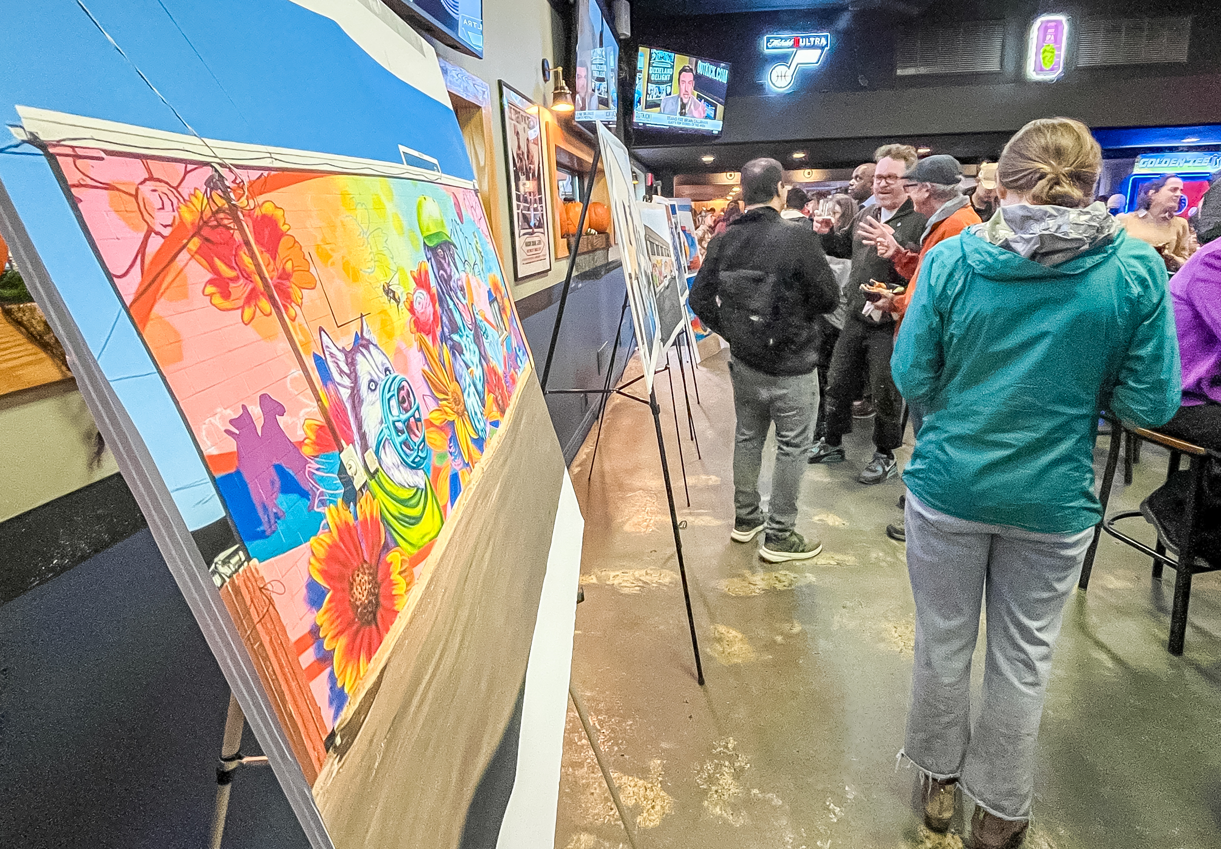 People look at photos of 10 new murals added to the Ballpark neighborhood during an event at Big Willies in Salt Lake City on Thursday. The murals could reflect the neighborhood's emerging identity following the loss of the Salt Lake Bees.