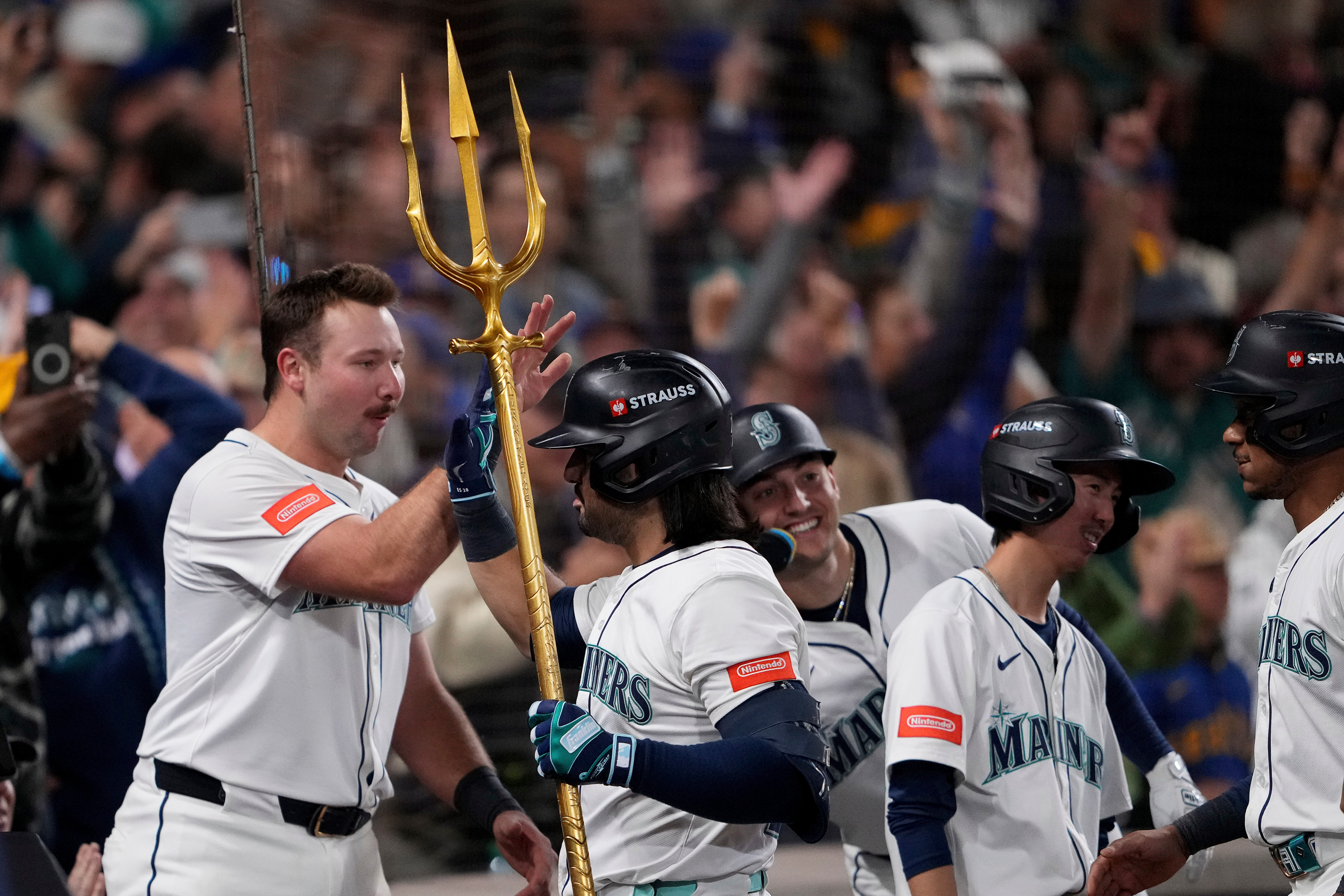 Seattle Mariners' Eugenio Suárez holds the trident after hitting a grand slam home run during the eighth inning in Game 5 of baseball's American League Championship Series against the Toronto Blue Jays, Friday, Oct. 17, 2025, in Seattle. 