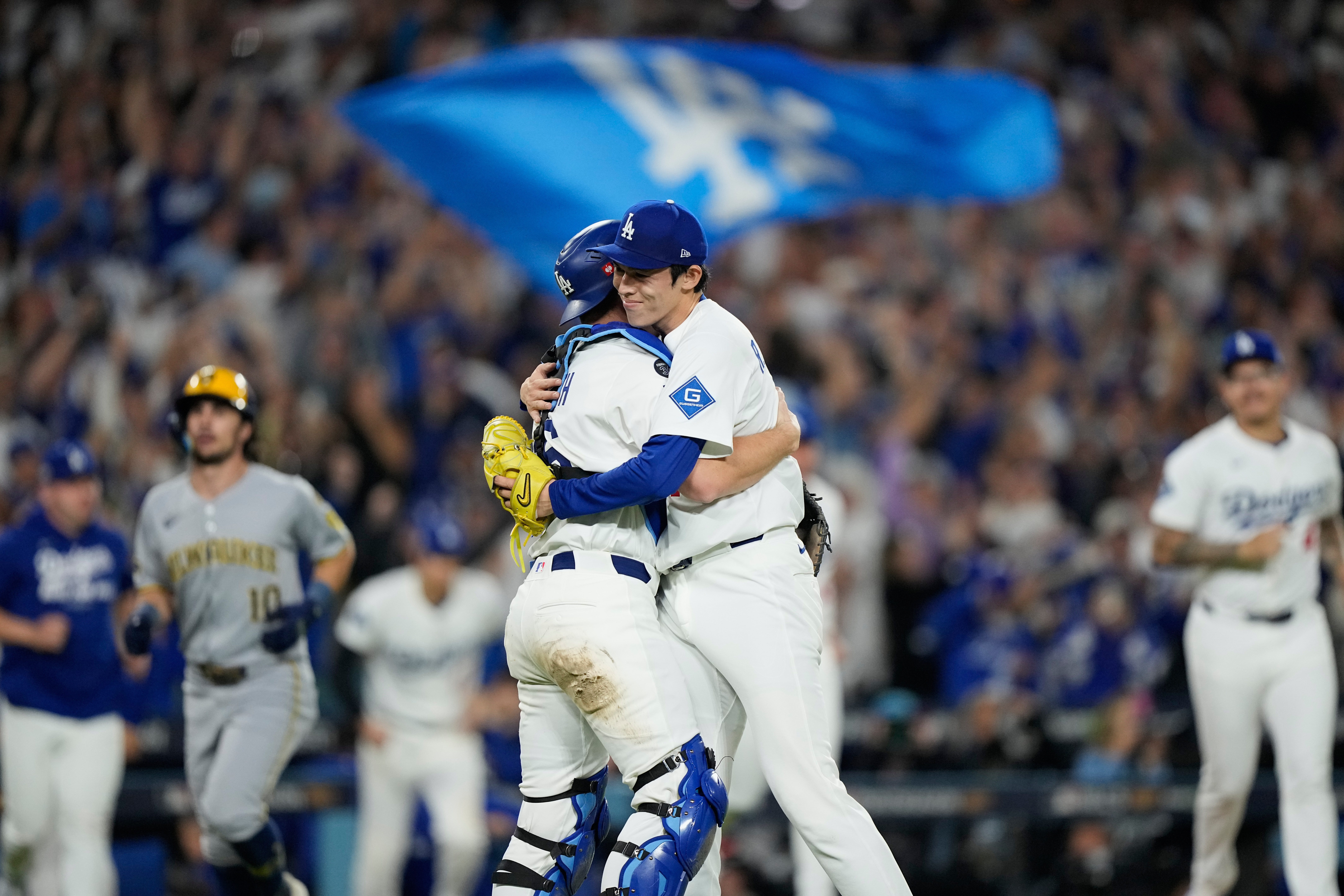 Los Angeles Dodgers pitcher Roki Sasaki and catcher Will Smith celebrates their win against the Milwaukee Brewers in Game 4 of baseball's National League Championship Series, Friday, Oct. 17, 2025, in Los Angeles.