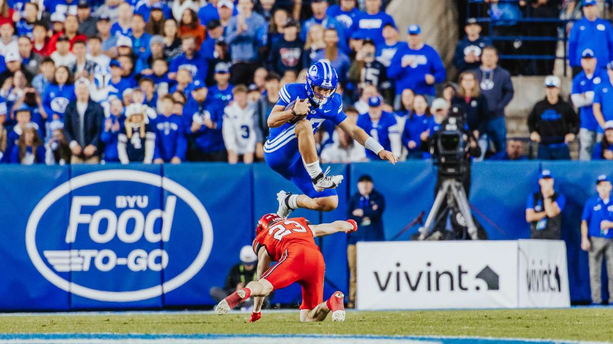 BYU quarterback Bear Bachmeier leaps over Utah's Jackson Bennee during a Big 12 football game against Utah, Saturday, Oct. 18, 2025 at LaVell Edwards Stadium.