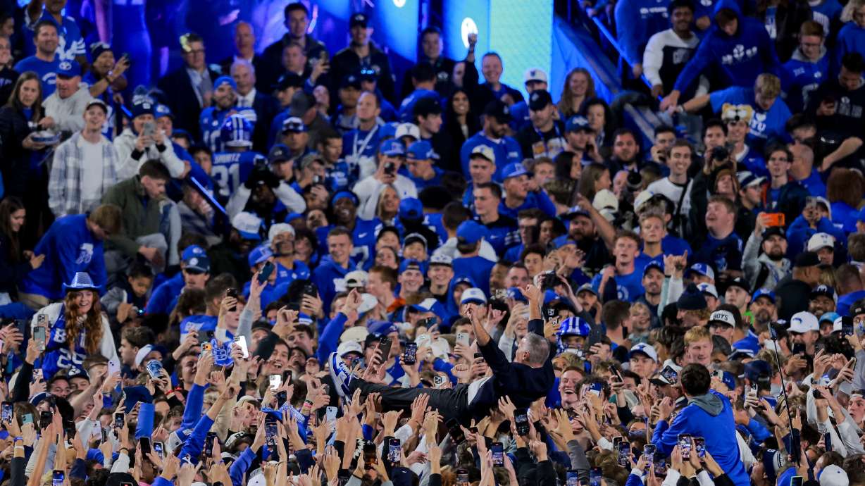 BYU president Shane Reese crowd surfs after BYU fans rushed the field after BYU defeated Utah 24-21 at LaVell Edwards Stadium in Provo on Saturday, Oct. 18, 2025.