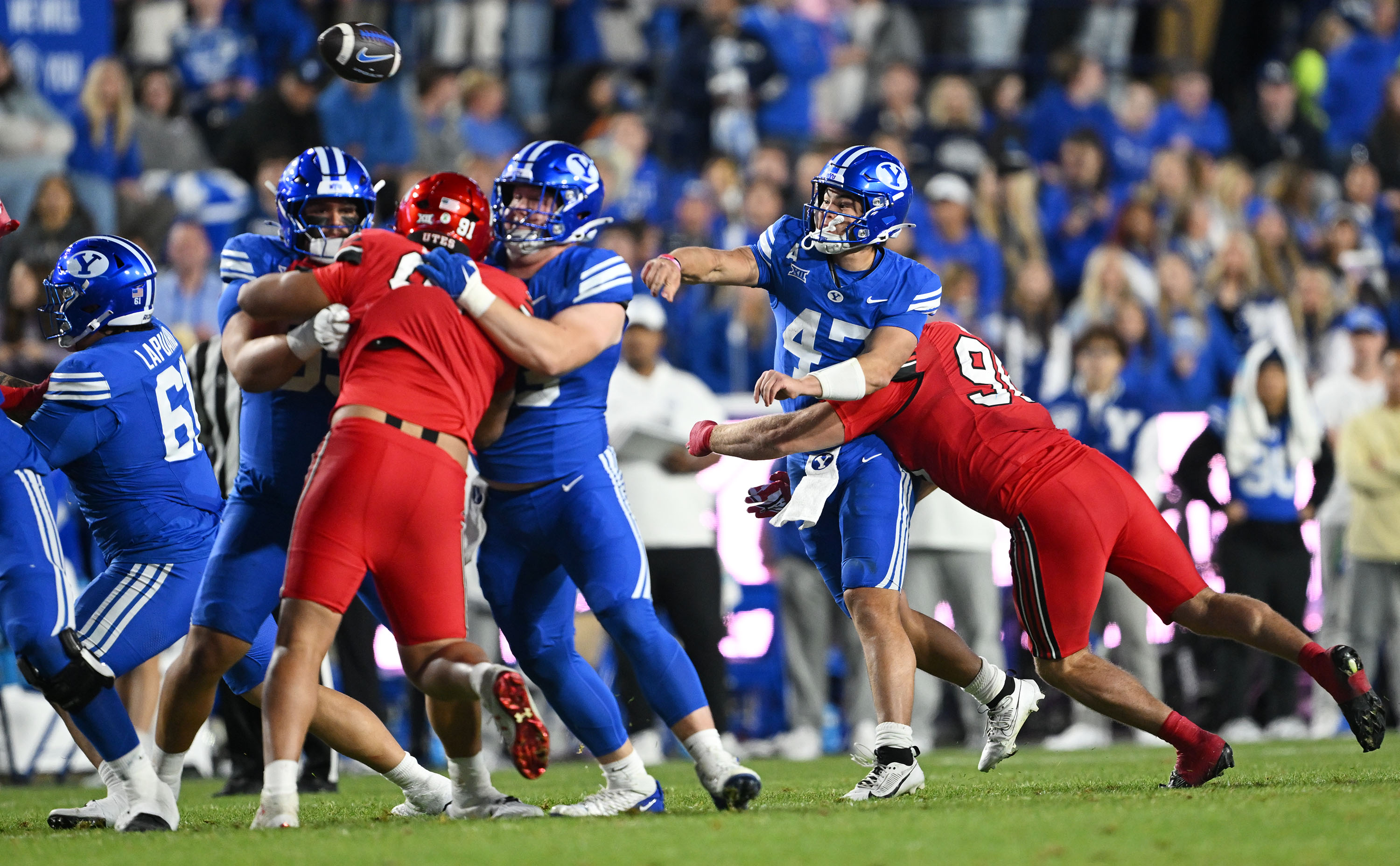 BYU quarterback Bear Bachmeier (47) gets rid of the ball just ahead of Utah defensive end John Henry Daley (90) as BYU and Utah play at LaVell Edwards Stadium in Provo on Saturday, Oct. 18, 2025.