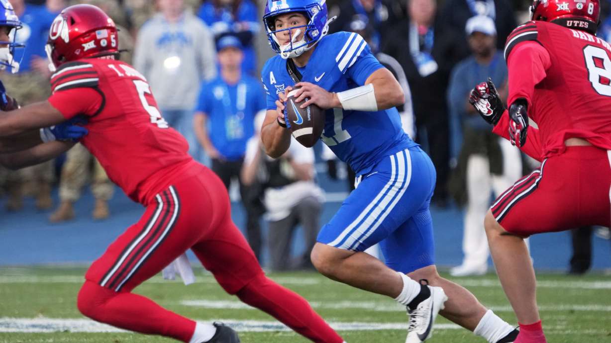BYU quarterback Bear Bachmeier (47) rolls out to pass as Utah linebacker Lander Barton (8) and Utah safety Tao Johnson (5) defend during the first half of an NCAA college football game Saturday, Oct. 18, 2025, in Provo, Utah.