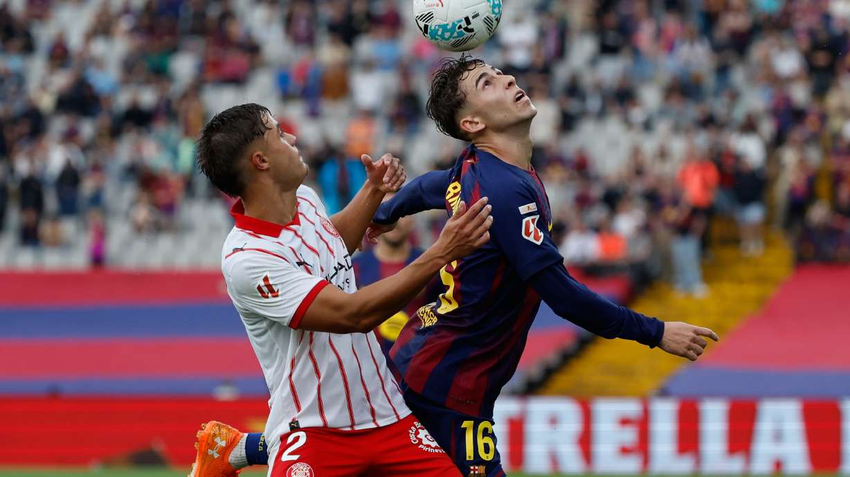 Girona's Hugo Rincon, left, and Barcelona's Fermin Lopez fight for the ball during a La Liga soccer match between Barcelona and Girona in Barcelona, Spain, Saturday, Oct. 18, 2025. AP Photo/Joan Monfort)
