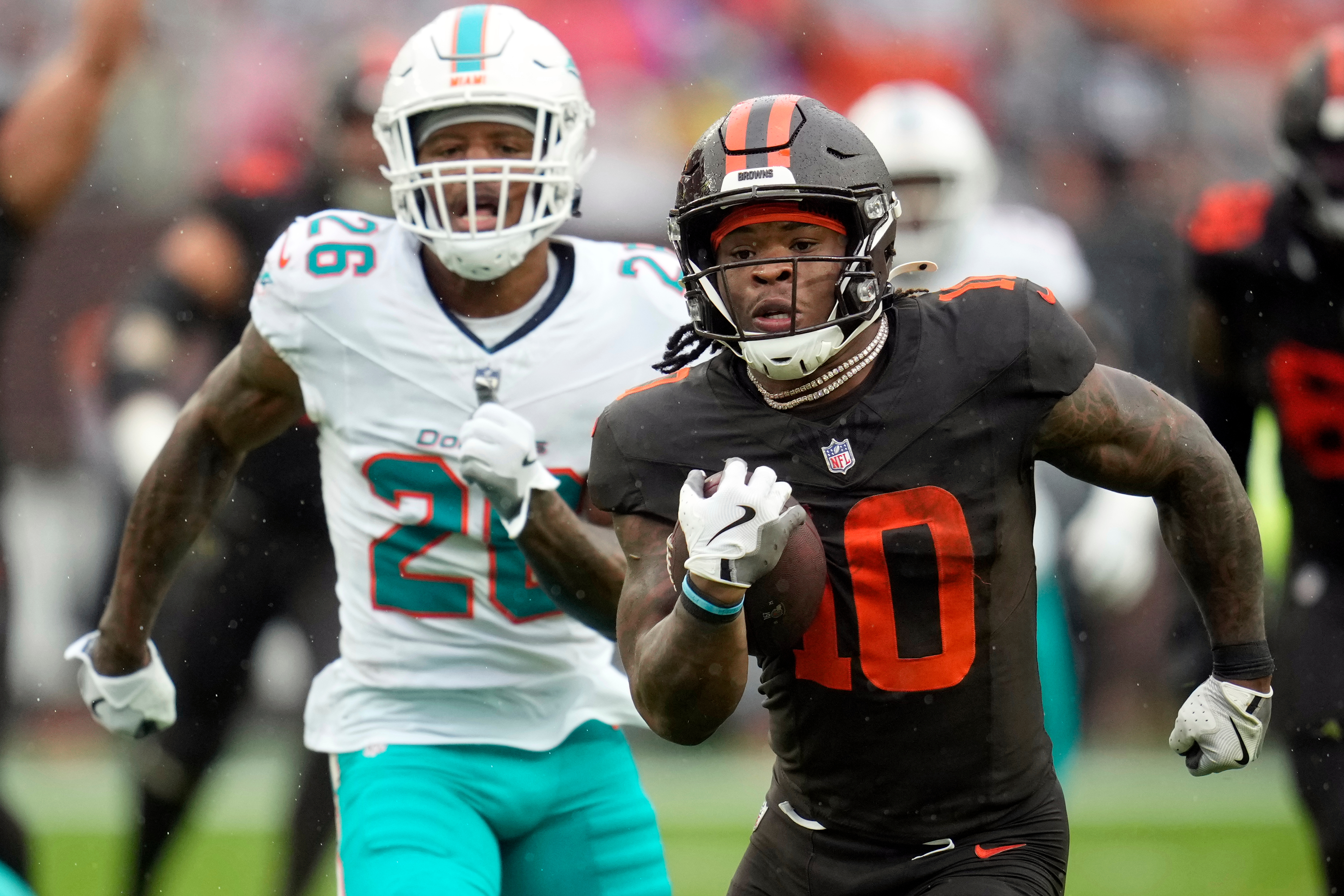 Cleveland Browns running back Quinshon Judkins (10) carries the ball ahead of Miami Dolphins cornerback Rasul Douglas (26) in the first half of an NFL football game in Cleveland, Sunday, Oct. 19, 2025. 