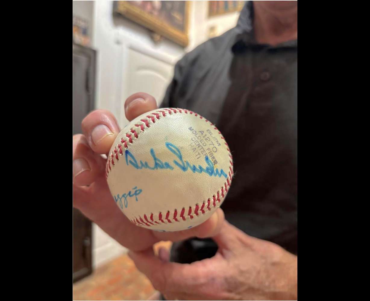 At Moon's Rare Books in Provo, columnist Lee Benson holds a baseball with Hall of Famer Duke Snider's autograph.