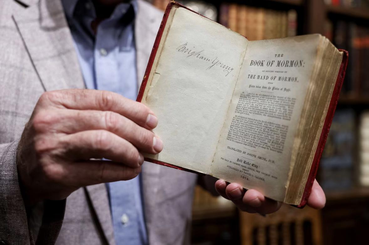 Reid Moon displays a copy of the Book of Mormon that belonged to Hyrum Smith during a private showing of his collection at Moon's Rare Books in Provo on Oct. 3.