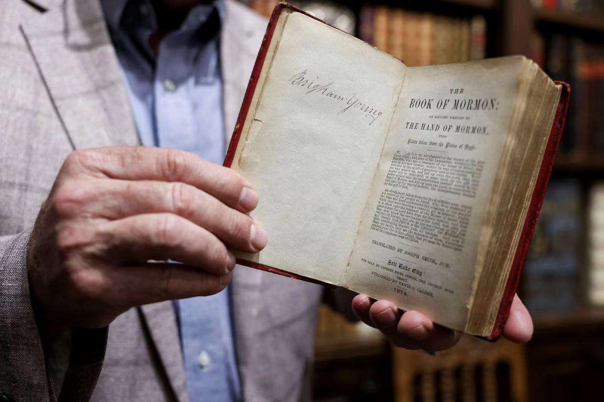 Reid Moon displays a copy of the Book of Mormon that belonged to Hyrum Smith during a private showing of his collection at Moon's Rare Books in Provo on Oct. 3.