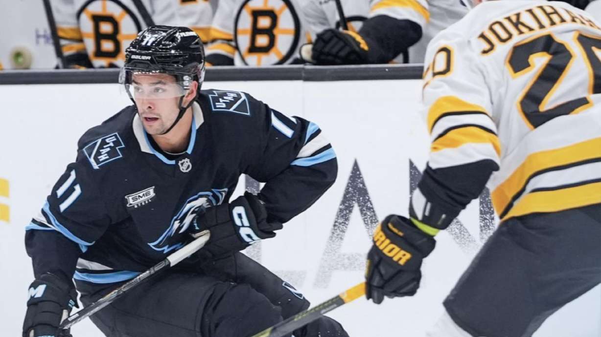 Dylan Guenther, left, skates against the Boston Bruins.