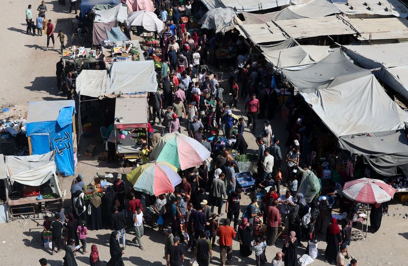 Palestinians shop at a market, amid a ceasefire between Israel and Hamas, in Khan Younis, southern Gaza Strip, Monday.