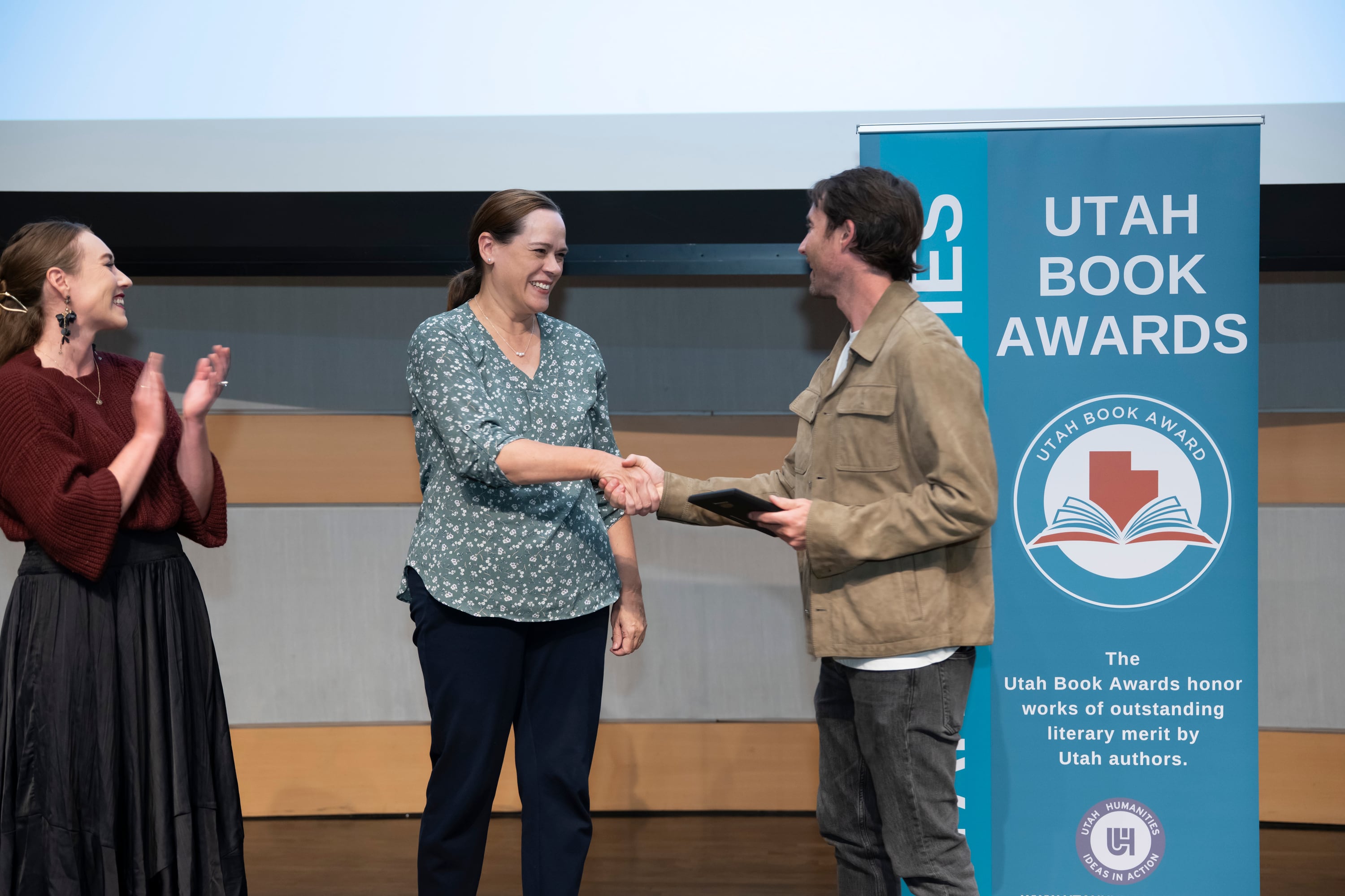 Author Heather B. Moore shakes hands with Josh Wennergren, director of Higher Education Access, at the Utah Book Awards at the Salt Lake Main Library on Oct. 10.