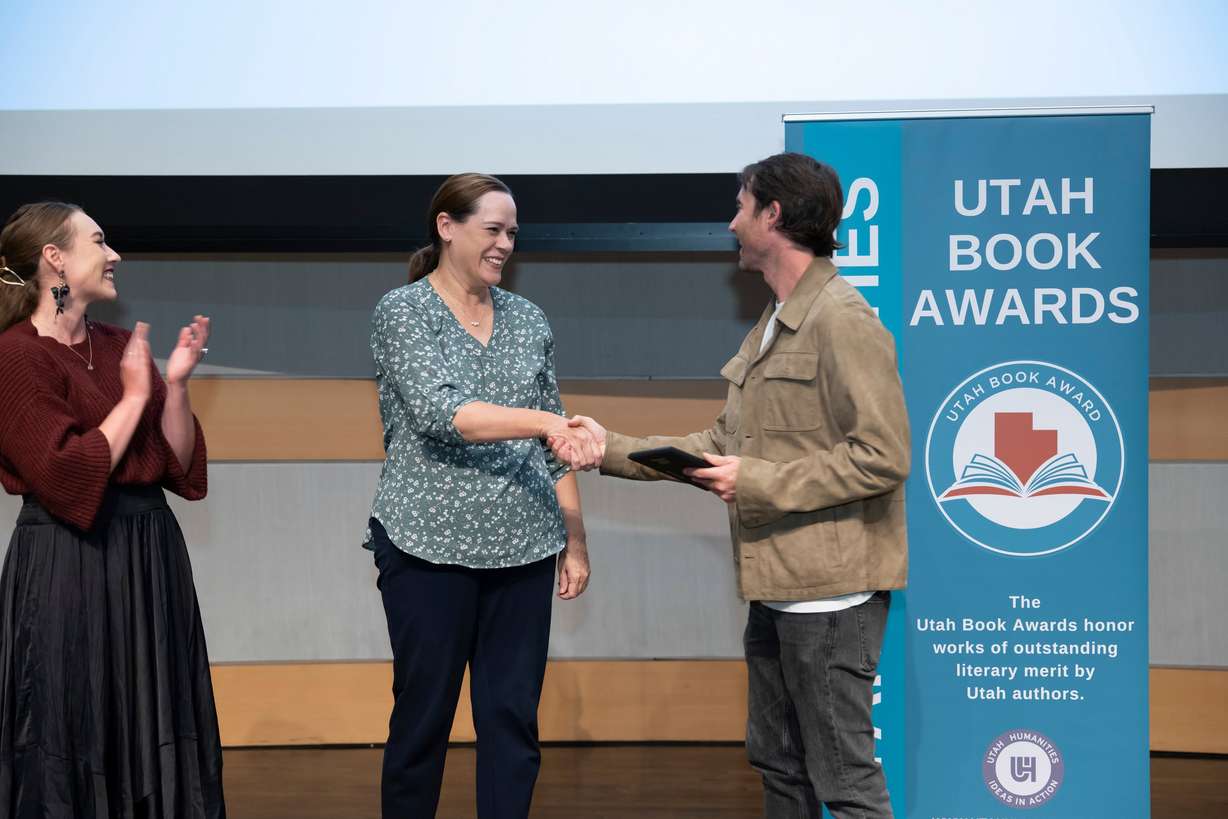 Author Heather B. Moore shakes hands with Josh Wennergren, director of Higher Education Access, at the Utah Book Awards at the Salt Lake Main Library on Oct. 10.