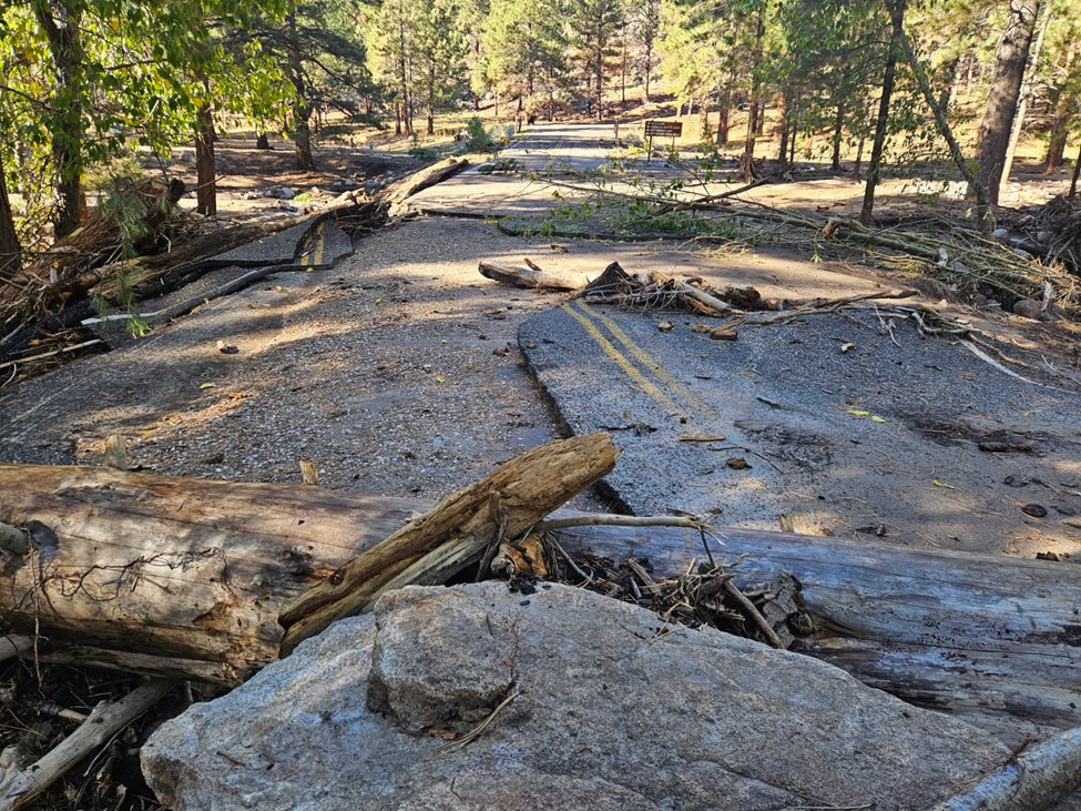 Road damage and debris from recent flash flooding is shown in an undated photo over a water channel in Pine Valley.
