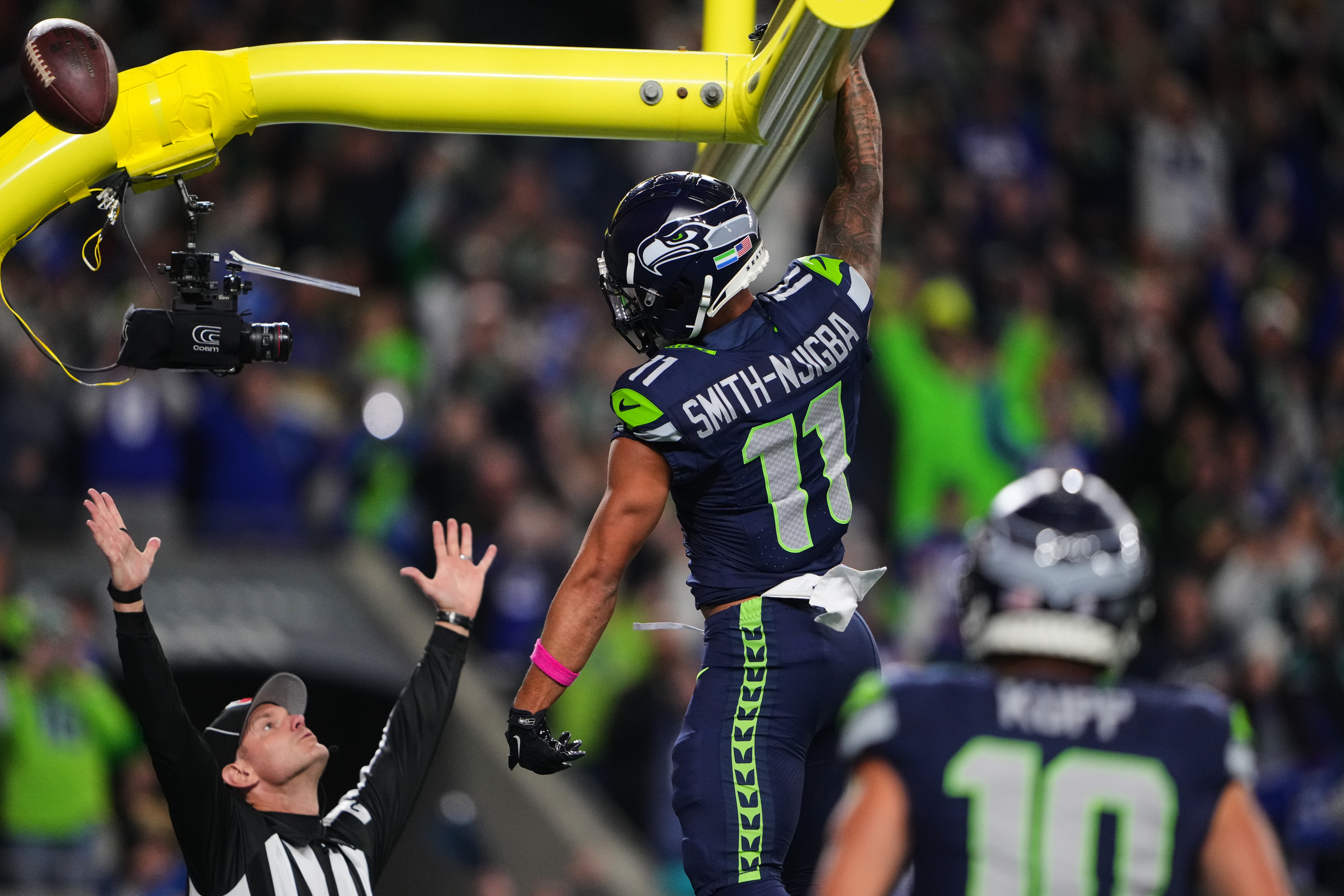 Seattle Seahawks wide receiver Jaxon Smith-Njigba (11) celebrates his touchdown catch as an official signals and looks on in the first half of an NFL football game Monday, Oct. 20, 2025, in Seattle. 