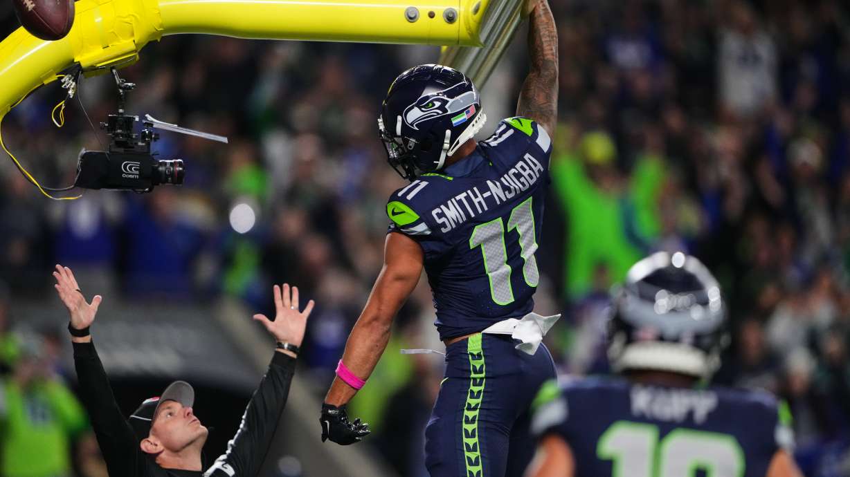 Seattle Seahawks wide receiver Jaxon Smith-Njigba (11) celebrates his touchdown catch as an official signals and looks on in the first half of an NFL football game Monday, Oct. 20, 2025, in Seattle.