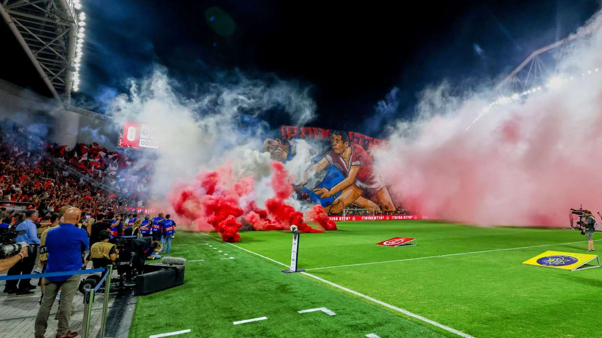 Smoke from flares thrown by fans fills the field before the soccer derby between Maccabi Tel Aviv and Hapoel Tel Aviv was called off Sunday after pregame disturbances led police to deem it unsafe to proceed at Bloomfield Stadium in Tel Aviv, Israel, Sunday, Oct. 19, 2025 .