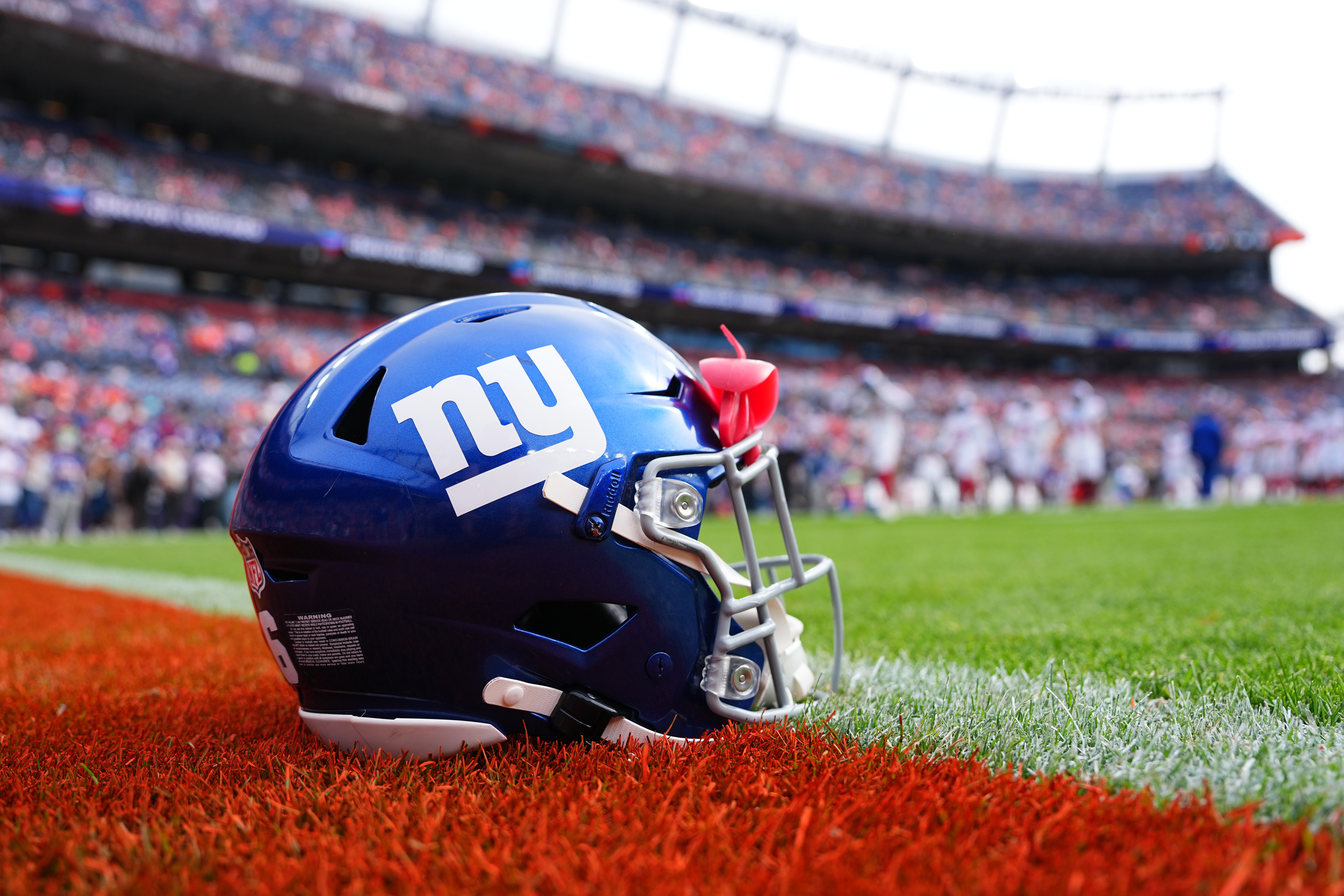 FILE - A New York Giants helmet is shown on the field before an NFL football game between the Denver Broncos and the Giants in Denver on Oct. 19, 2025. 