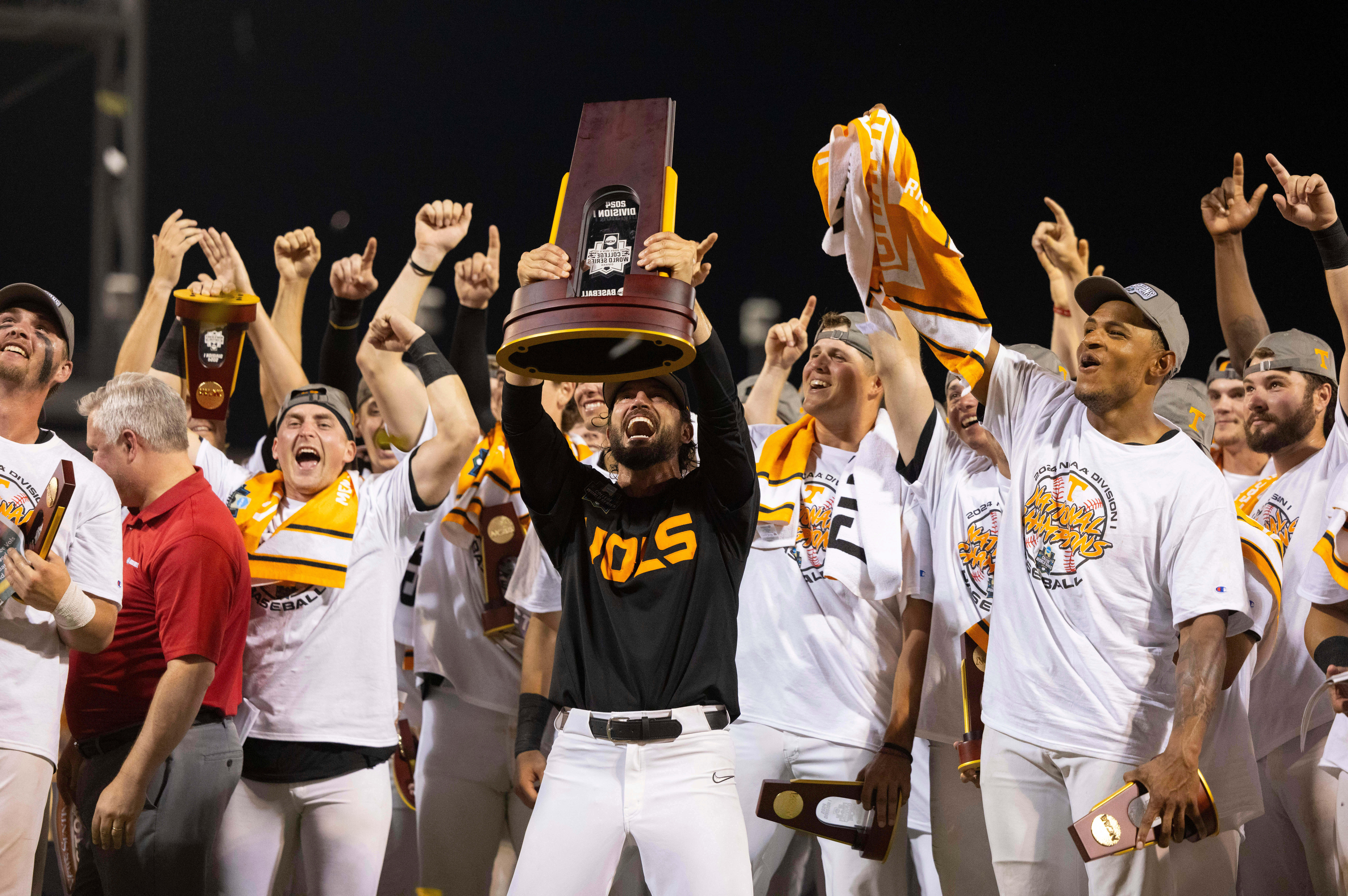 FILE - Tennessee coach Tony Vitello, center, hoists the championship trophy following his team's 6-5 victory against Texas A&M in Game 3 of the NCAA College World Series baseball finals in Omaha, Neb., June 24, 2024.