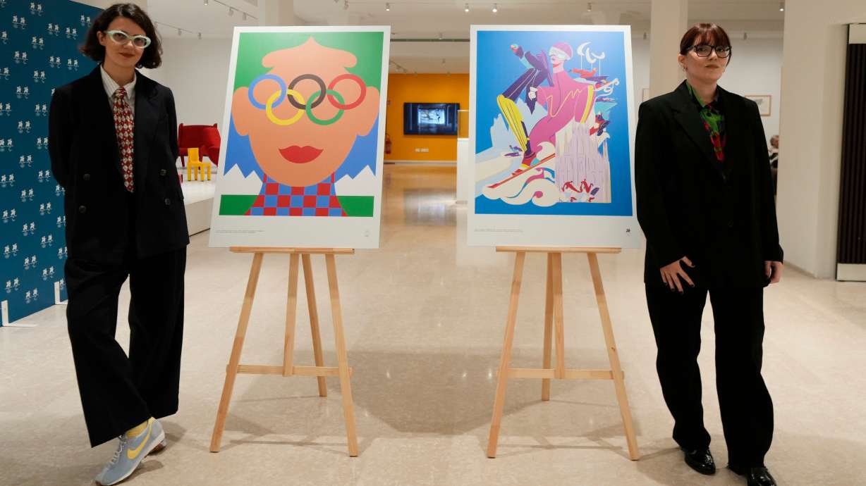 Artists Olimpia Zagnoli, left, and Carolina Altavilla pose next to Milano-Cortina 2026 Winter Olympics iconic posters presented during a press conference at Milan's Triennale permanent exhibition in Milan, Italy, Wednesday, Oct. 22, 2025.