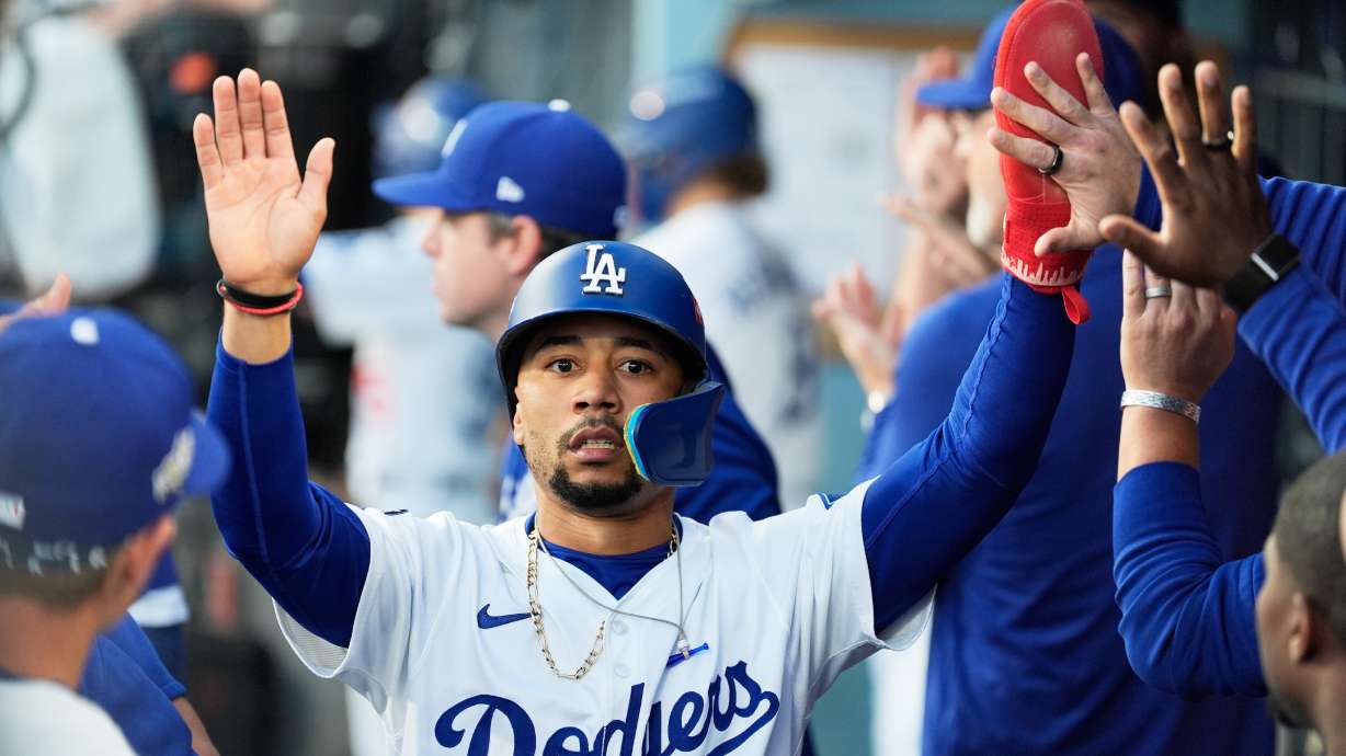 Los Angeles Dodgers' Mookie Betts celebrates in the dugout after scoring against the Milwaukee Brewers during the first inning in Game 4 of baseball's National League Championship Series, Friday, Oct. 17, 2025, in Los Angeles.