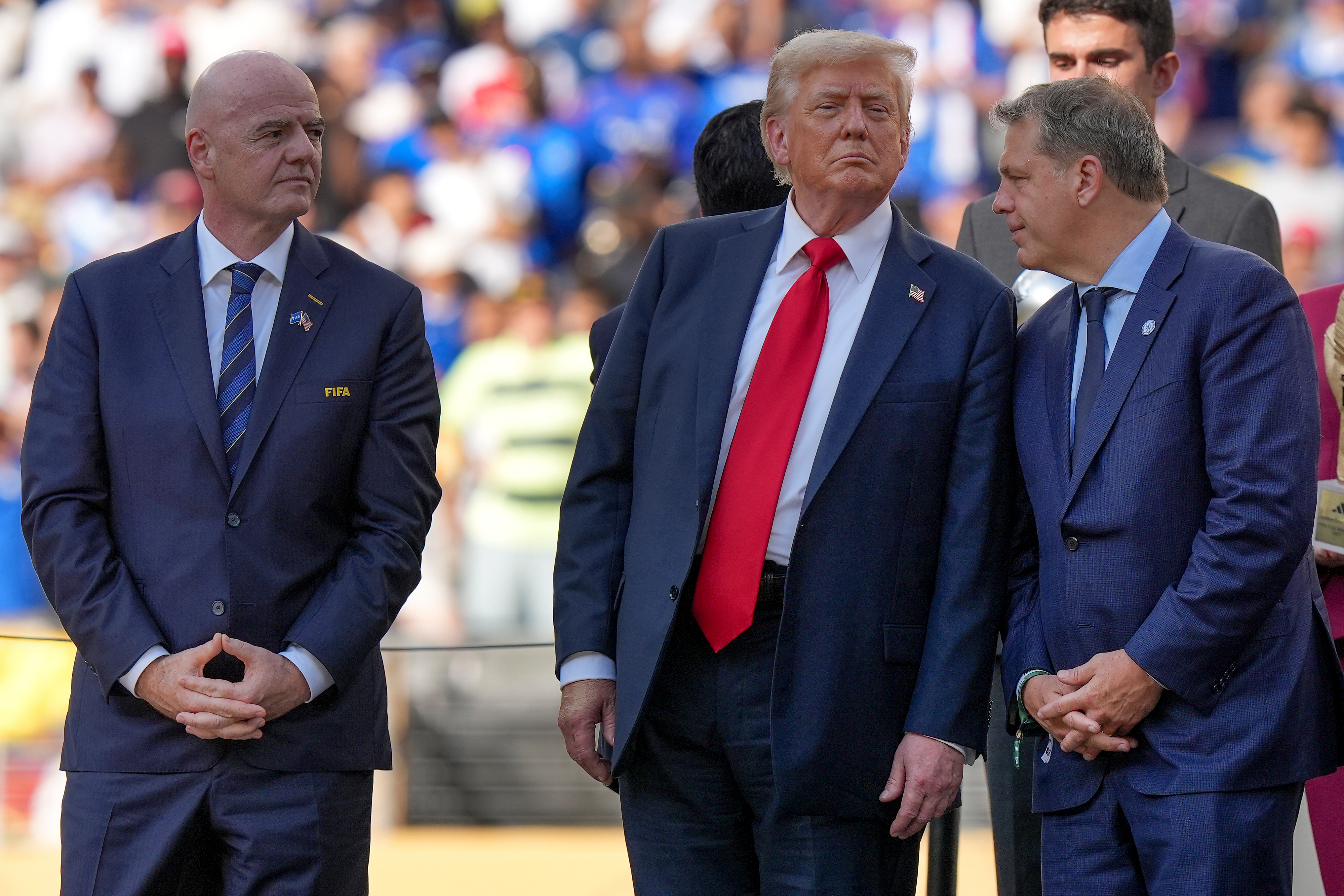 FILE - President Donald Trump, center, talks with Chelsea football club owner Todd Boehly, right, as FIFA president Gianni Infantino, left, looks on before the trophy ceremony of the Club World Cup final soccer match in East Rutherford, N.J., Sunday, July 13, 2025. 