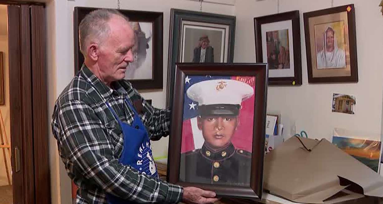 Artist J.R. Johansen holds a portrait of U.S. Marine David Espinoza, who died in Afghanistan, at Johansen's studio in Huntsville on Thursday. The portrait is for Espinoza's family.