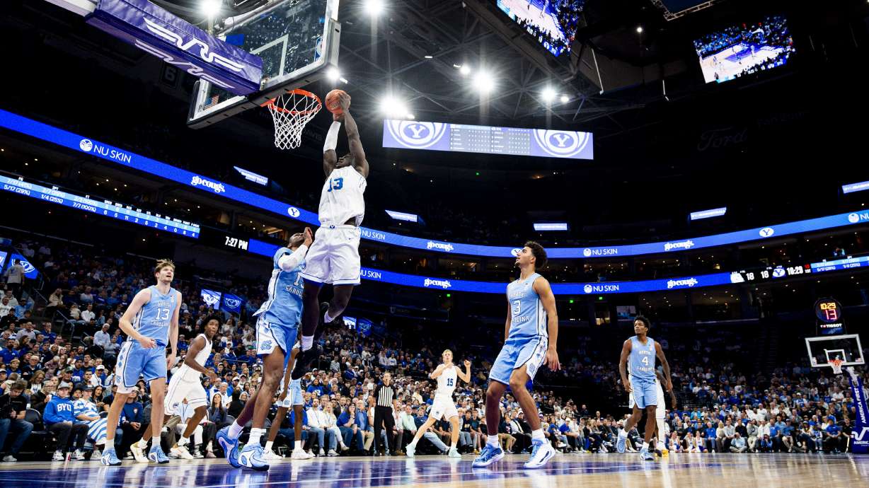 BYU center Keba Keita (13) dunks the ball while guarded by North Carolina forward Jarin Stevenson (15) during an NCAA men’s basketball exhibition game held at the Delta Center in Salt Lake City on Friday, Oct. 24, 2025.