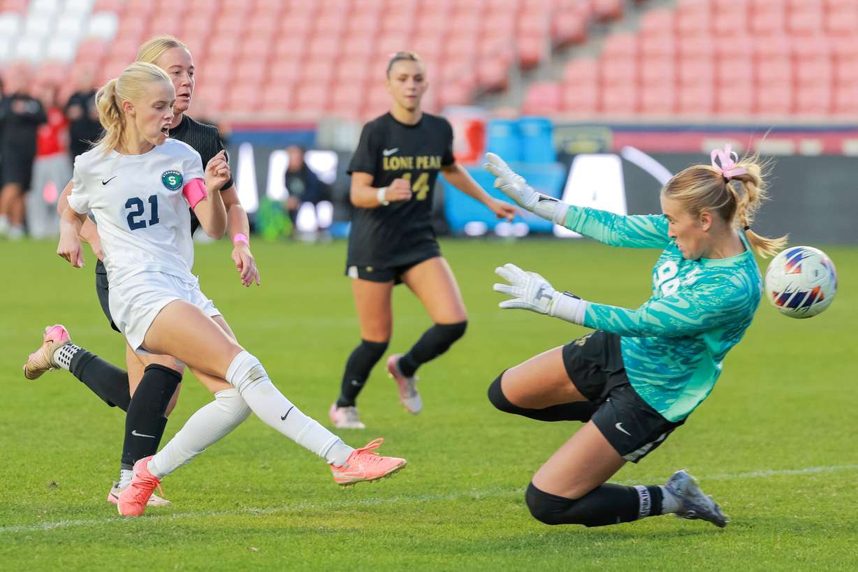 Syracuse’s Taylee Hughes (21) shoots the ball past Lone Peak goalkeeper Eliza Collings (99) to score the go-ahead goal during the second half of the girls 6A soccer state championship game at America First Field in Sandy on Friday, Oct. 24, 2025. Syracuse won 2-0.