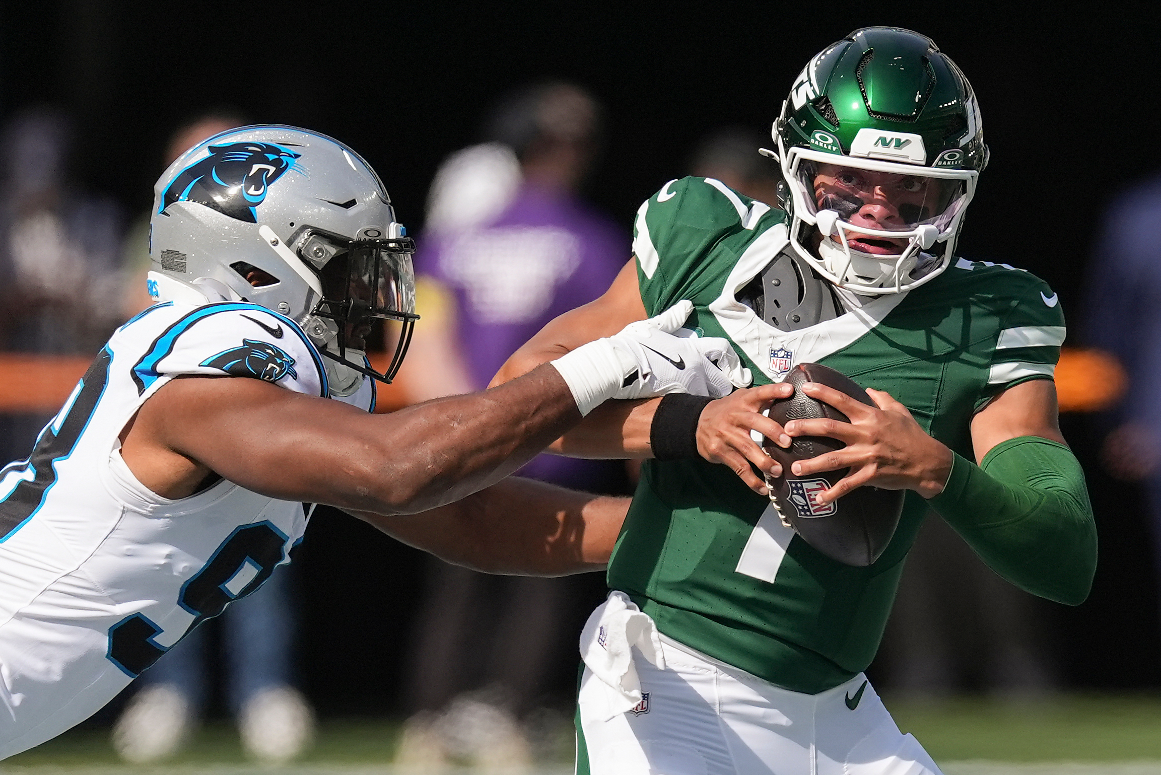 New York Jets quarterback Justin Fields (7) tries to avoid a tackle by Carolina Panthers linebacker D.J. Wonnum (98) during the first quarter of an NFL football game, Sunday, Oct. 19, 2025, in East Rutherford, N.J. 