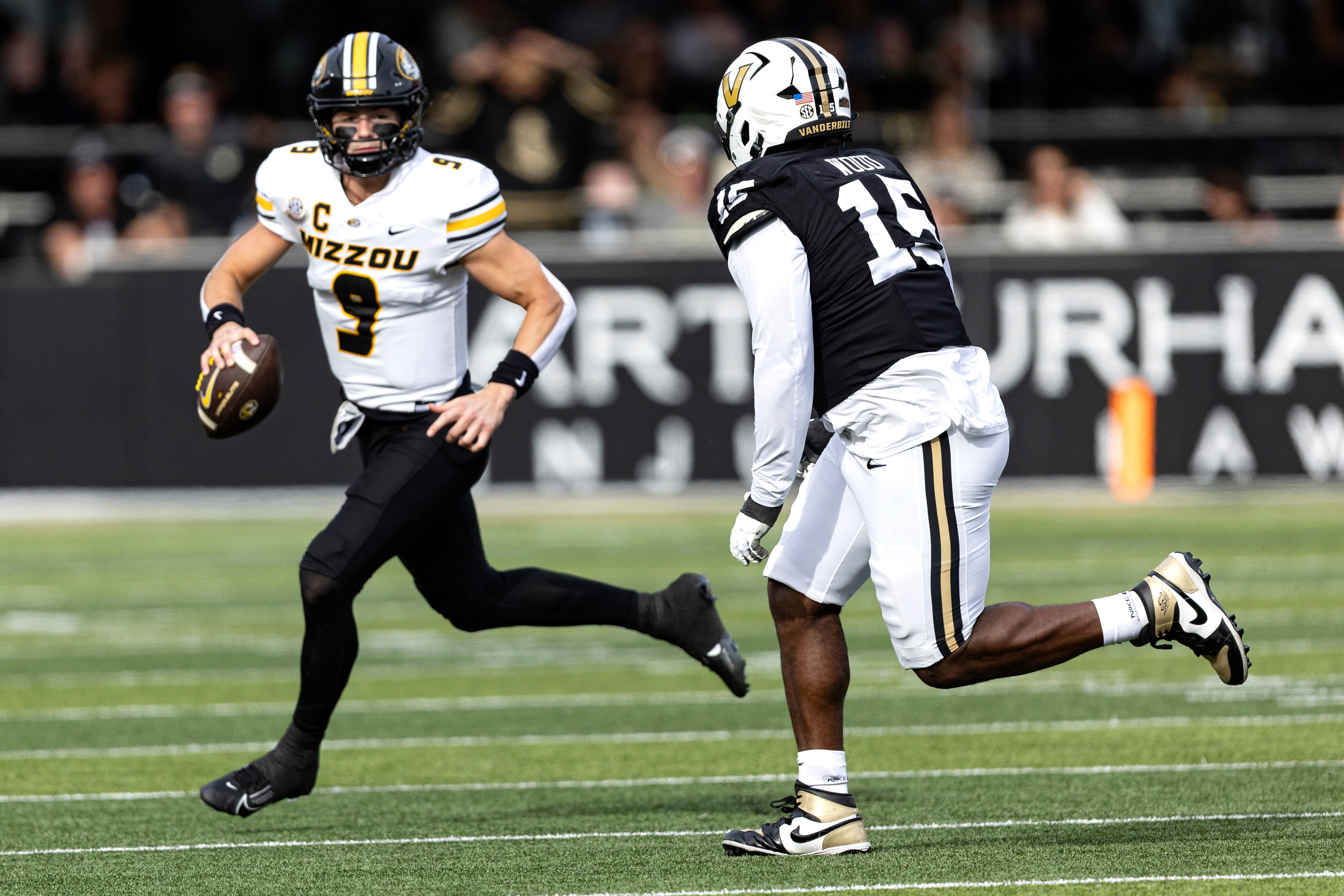 Missouri quarterback Beau Pribula (9) looks for a receiver as he's chased by Vanderbilt defensive lineman Zaylin Wood (15) during the first half of an NCAA college football game, Saturday, Oct. 25, 2025, in Nashville, Tenn. 