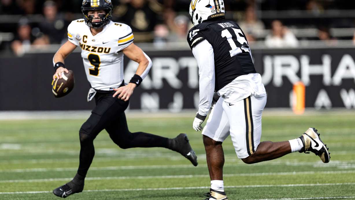 Missouri quarterback Beau Pribula (9) looks for a receiver as he's chased by Vanderbilt defensive lineman Zaylin Wood (15) during the first half of an NCAA college football game, Saturday, Oct. 25, 2025, in Nashville, Tenn.