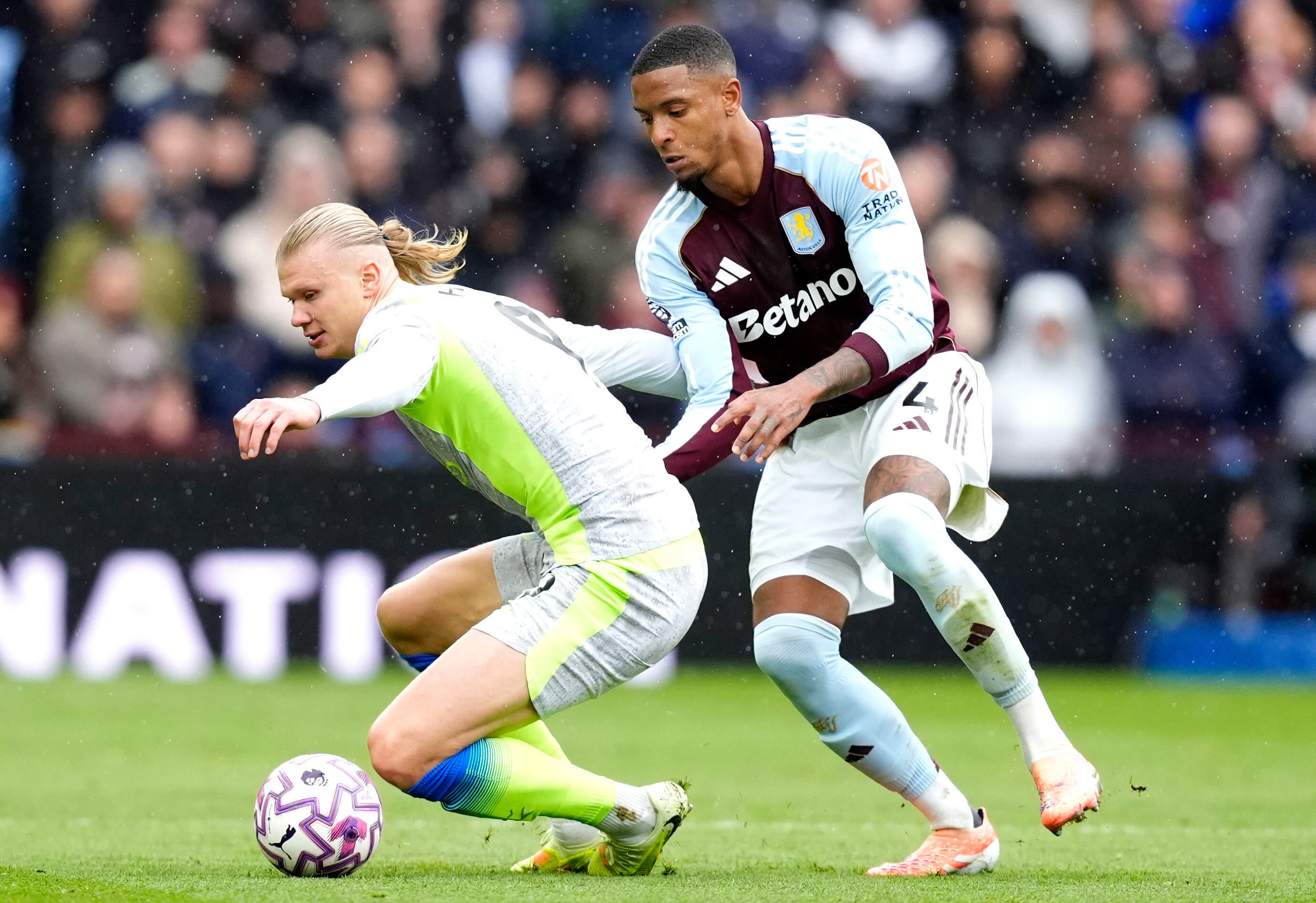 Manchester City's Erling Haaland (left) and Aston Villa's Ezri Konsa battle for the ball during the English Premier League match between Aston Villa and Manchester City, in Birmingham, England, Sunday Oct. 26, 2025. 