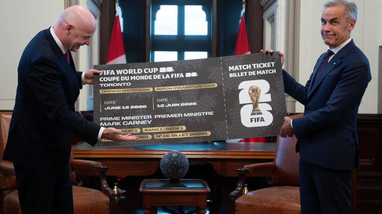 Canada Prime Minister Mark Carney, right, is presented with a novelty World Cup ticket by FIFA President Gianni Infantino on Parliament Hill in Ottawa, Ontario, Friday, Oct. 10, 2025.