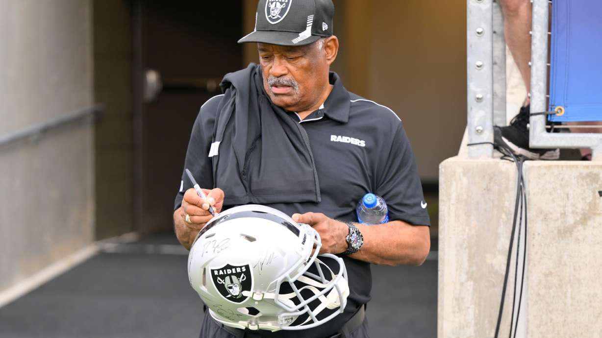 FILE - Former Oakland Raiders safety George Atkinson signs his autograph before the NFL football exhibition Hall of Fame Game between the Las Vegas Raiders and the Jacksonville Jaguars, Aug. 4, 2022, in Canton, Ohio.
