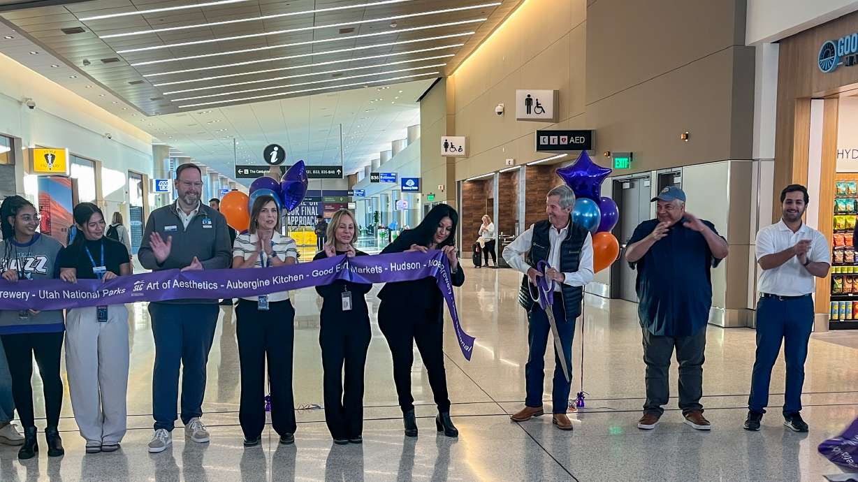 Bill Wyatt, director of Salt Lake City International Airport, third from right, cuts a ribbon to signal the opening of 10 new gates and six new concessions in Concourse B on Tuesday.