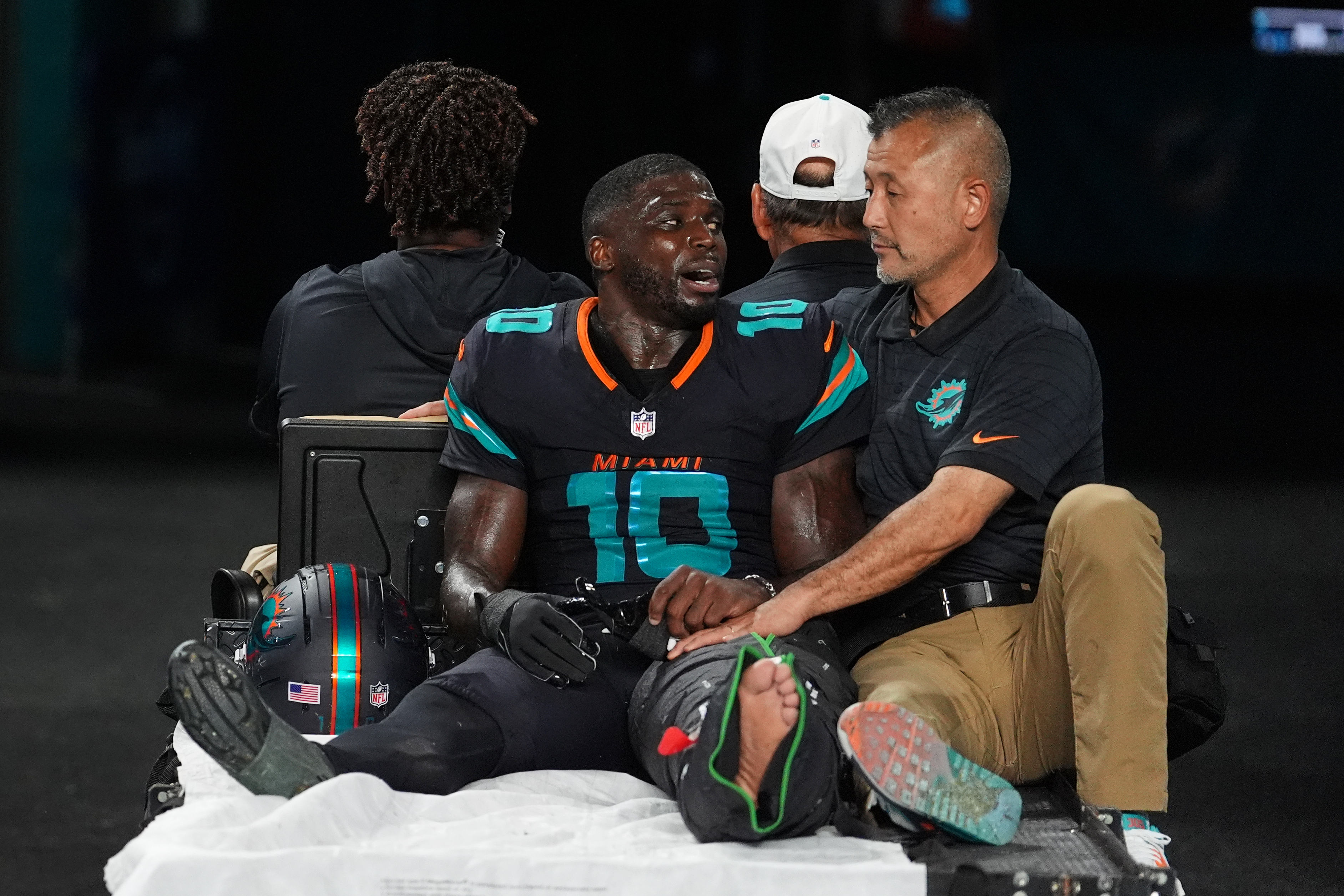 Miami Dolphins wide receiver Tyreek Hill (10) talks with a staff member as he is carted off the field after suffering an unknown lower leg injury in the second half of an NFL football game against the New York Jets, Monday, Sept. 29, 2025, in Miami Gardens, Fla. 