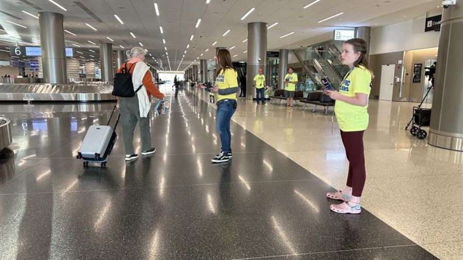 Several air traffic controllers gather at the baggage claim area of the Salt Lake City International Airport on their time off, handing out leaflets and urging travelers to pressure lawmakers to end the shutdown so they can get paid, Tuesday, in Salt Lake City.