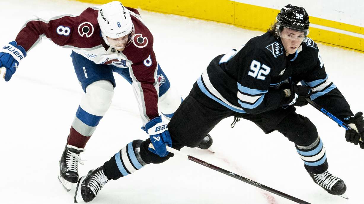 Utah Mammoth center Logan Cooley (92) controls the puck while defended by Colorado Avalanche defenseman Cale Makar (8) during an NHL game held at the Delta Center in Salt Lake City on Tuesday, Oct. 21, 2025.
