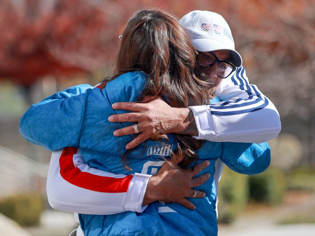 Mayor Erin Mendenhall hugs Bill Schuffenhauer, Olympic bobsled silver medalist and Utah native, during a press conference to announce a public watch party for the Milan-Cortina 2026 Winter Olympic and Paralympic Games at Library Square in Salt Lake City on Wednesday.