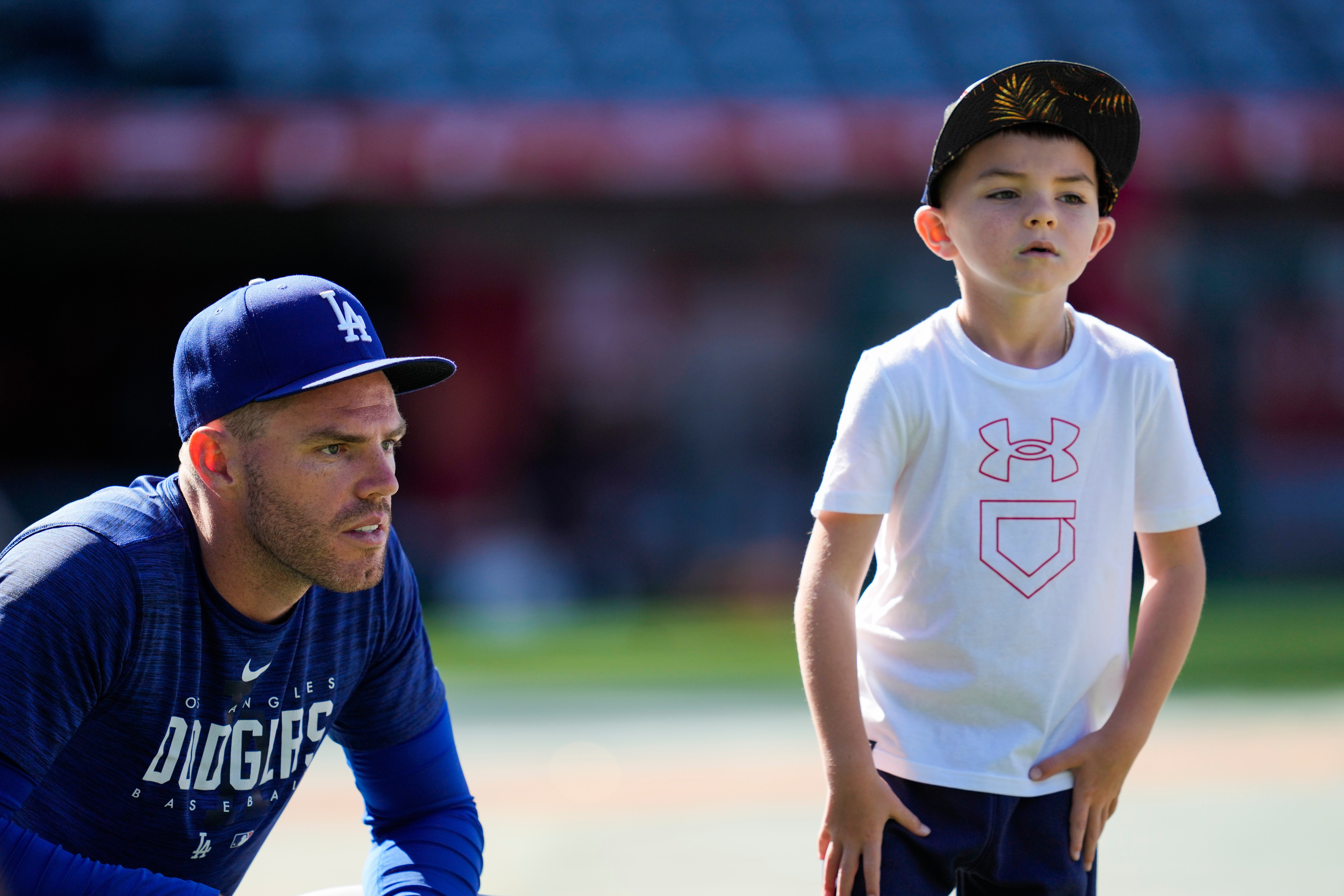 FILE - Los Angeles Dodgers first baseman Freddie Freeman (5) and his son, Charlie Freeman, participate in batting practice before a baseball game against the Los Angeles Angels in Anaheim, Calif., June 21, 2023. 