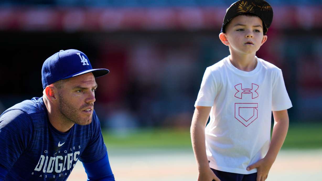 FILE - Los Angeles Dodgers first baseman Freddie Freeman (5) and his son, Charlie Freeman, participate in batting practice before a baseball game against the Los Angeles Angels in Anaheim, Calif., June 21, 2023.