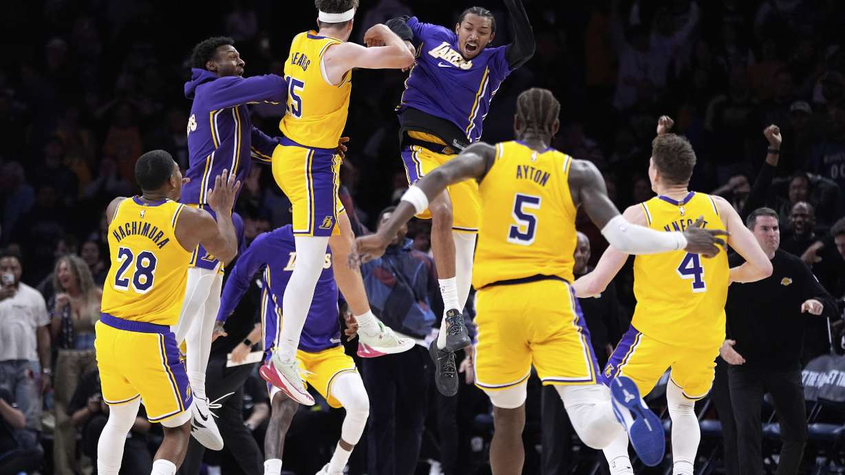 Los Angeles Lakers guard Austin Reaves (15) celebrates with teammates after making the game-winning shot at the buzzer in an NBA basketball game against the Minnesota Timberwolves, Wednesday, Oct. 29, 2025, in Minneapolis.