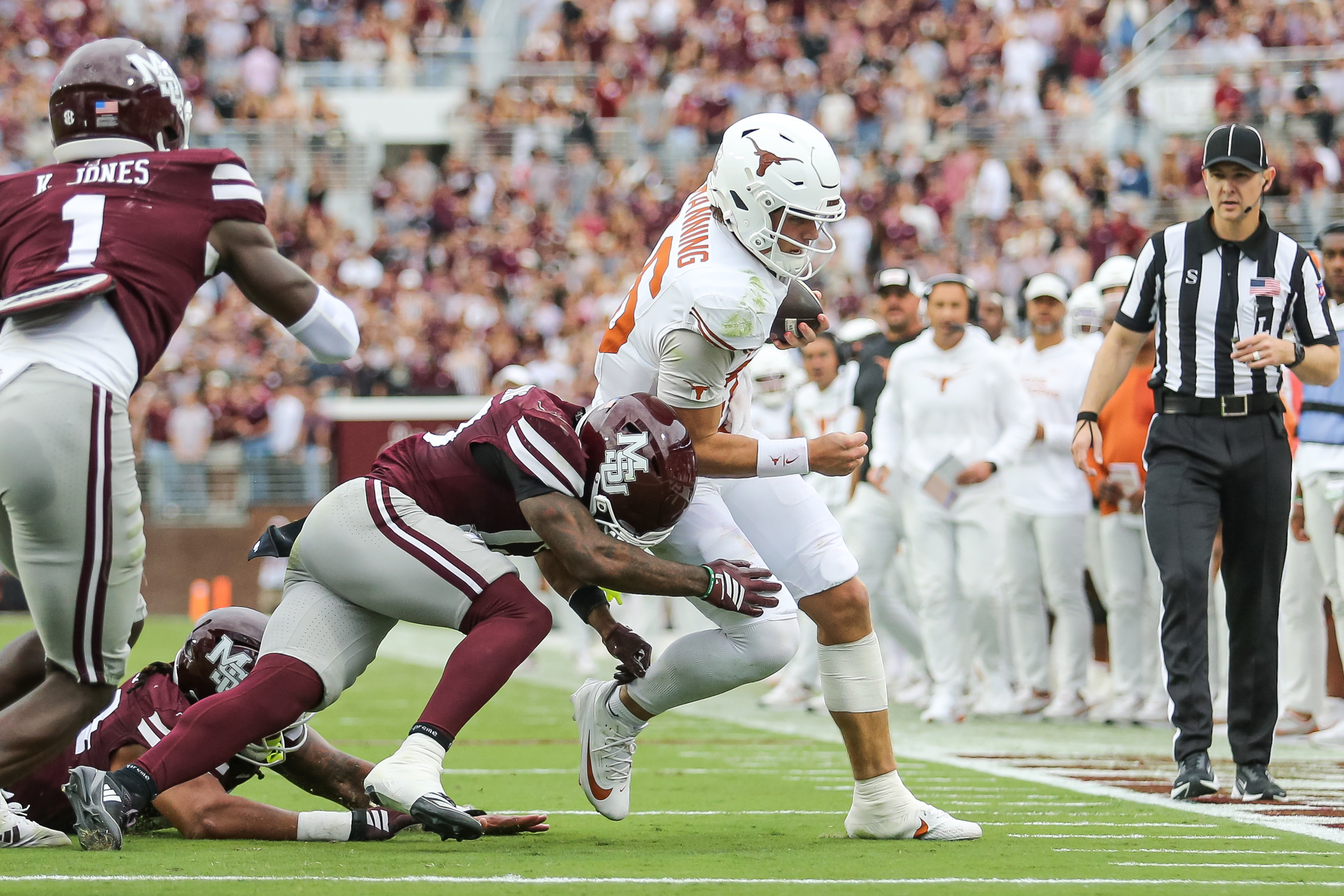 Texas quarterback Arch Manning, center right, runs out of bounds against Mississippi State safety Jahron Manning, center left, during the first half of an NCAA college football game in Starkville, Miss., Saturday, Oct. 25, 2025. 