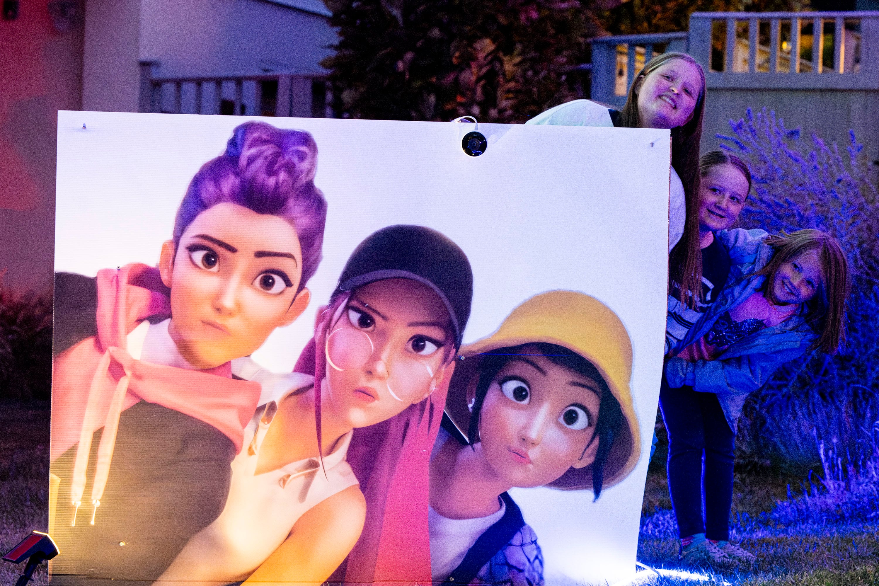 Arie Woolf with her sisters, Evie and Graysie, at their home, decorated with things from "KPop Demon Hunters," Tuesday. Their mother, Chelsey Vreeken, has turned their viral house decor into a springboard for a good cause.