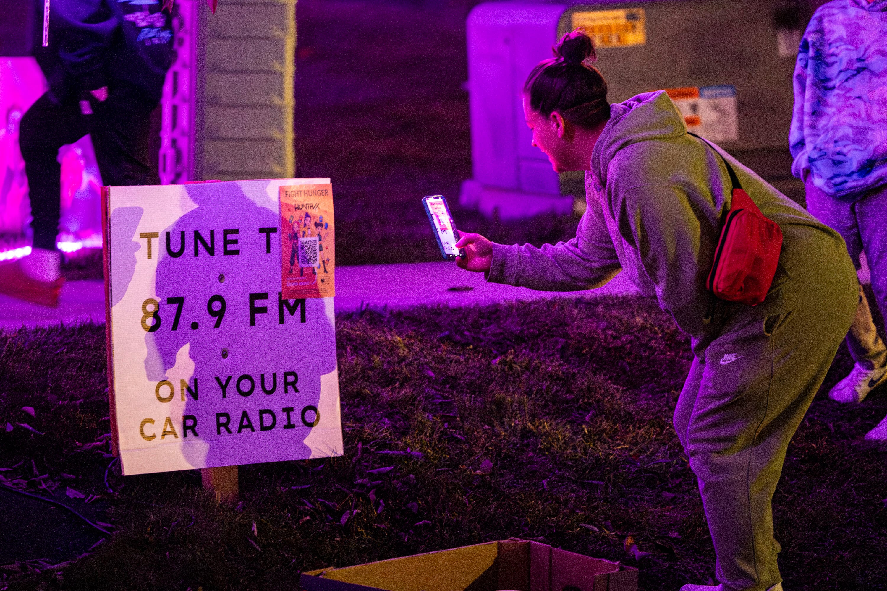 Hollie Llewelyn scans a QR code to a food drive posted outside Chelsey Vreeken's house in South Jordan on Tuesday. Vreeken said the community connections being made is the best part of watching visitors come by the house.