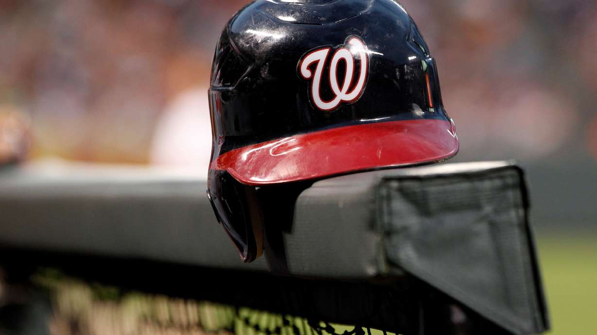FILE - A Washington Nationals helmet sits in the dugout railing before a baseball game against the Baltimore Orioles in Baltimore, Friday, June 22, 2012.