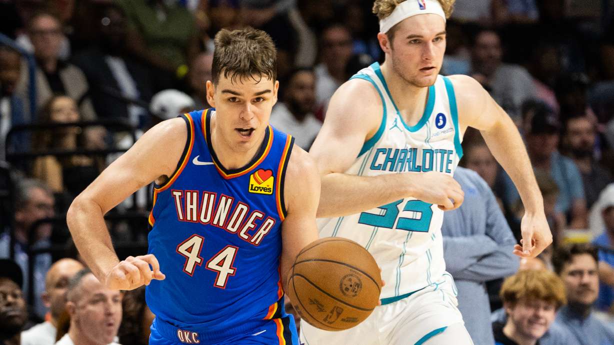 Oklahoma City Thunder guard Nikola Topic, left, drives the ball upcourt against Charlotte Hornets forward Liam McNeeley, right, during the second half of an NBA basketball preseason game in North Charleston, S.C., Sunday, Oct. 5, 2025.