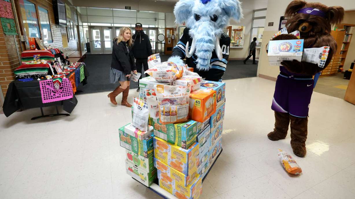 Tusky, the Utah Mammoth mascot, and Jazz Bear move donated food at Lincoln Elementary School after a press conference to announce a donation to Utah’s School Nutrition Program in South Salt Lake Thursday.